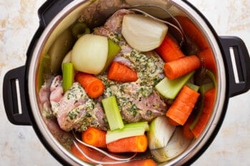 An instant pot filled with turkey breast, carrots, onions, and celery.
