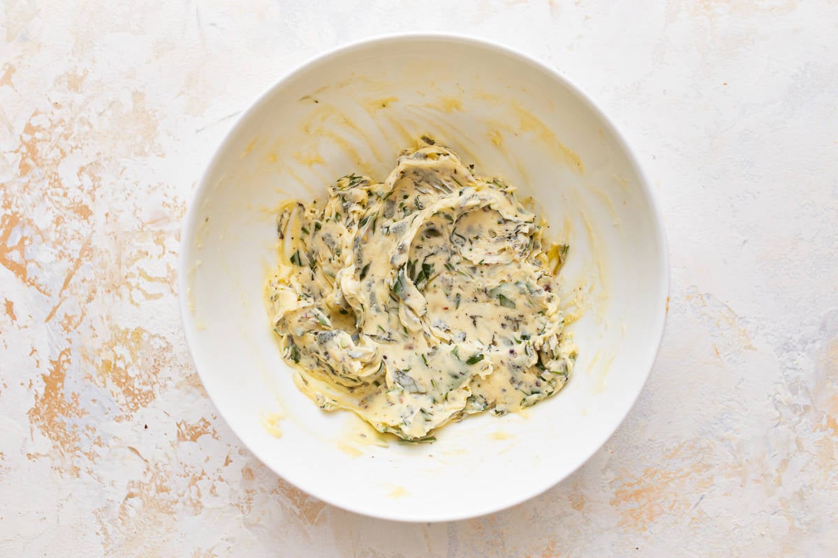 A white bowl with a mixture of cheese and spinach.