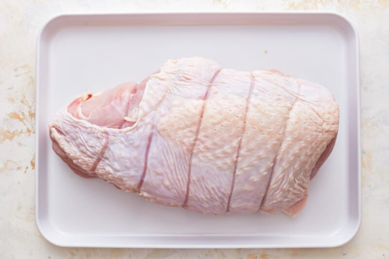 uncooked turkey breast on a white tray.
