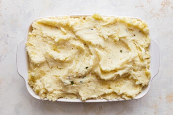 Mashed potatoes in a white dish on a table.
