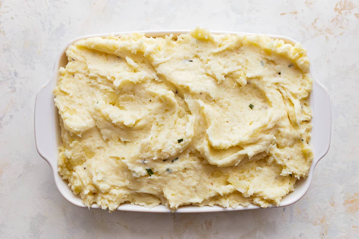 Mashed potatoes in a white dish on a table.