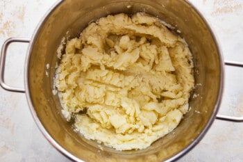 Mashed potatoes in a pot on a white background.