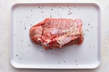 A piece of meat on a white plate.