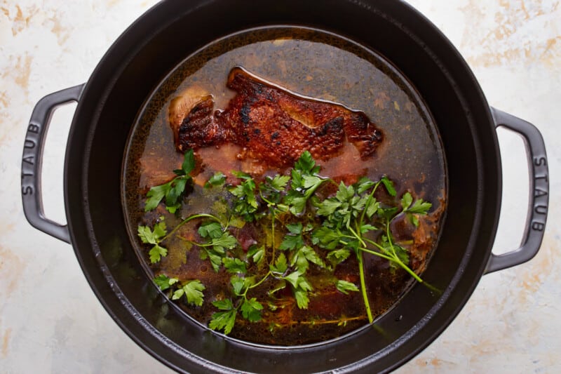 A pot with meat and herbs in it.
