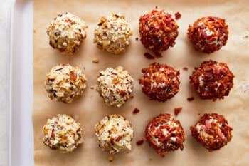 Cheese ball bites lined up on a baking sheet.