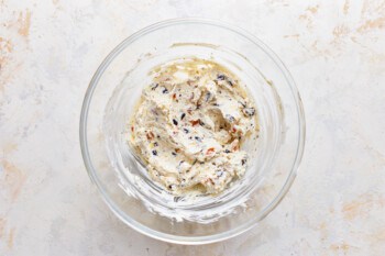 A glass bowl filled with a cream cheese mixture.