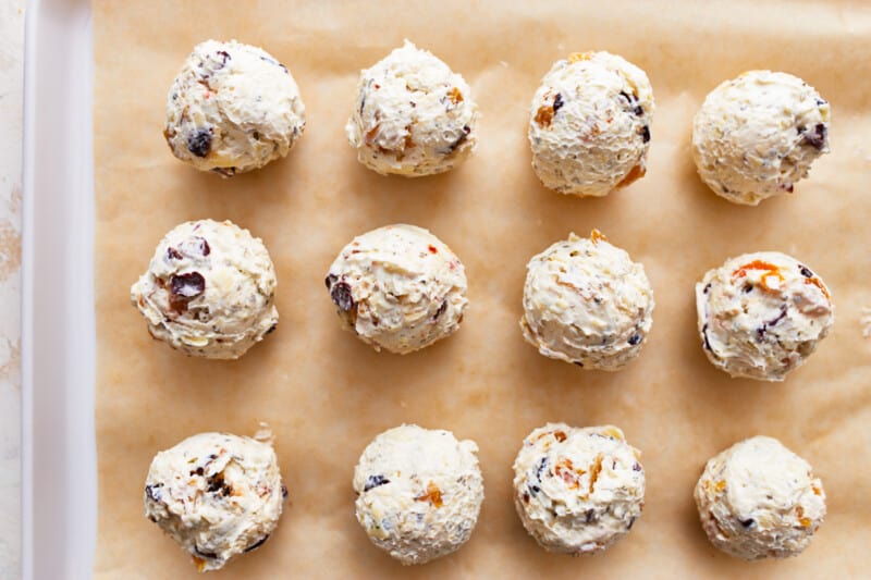 Mini cheese balls lined up on a baking sheet.