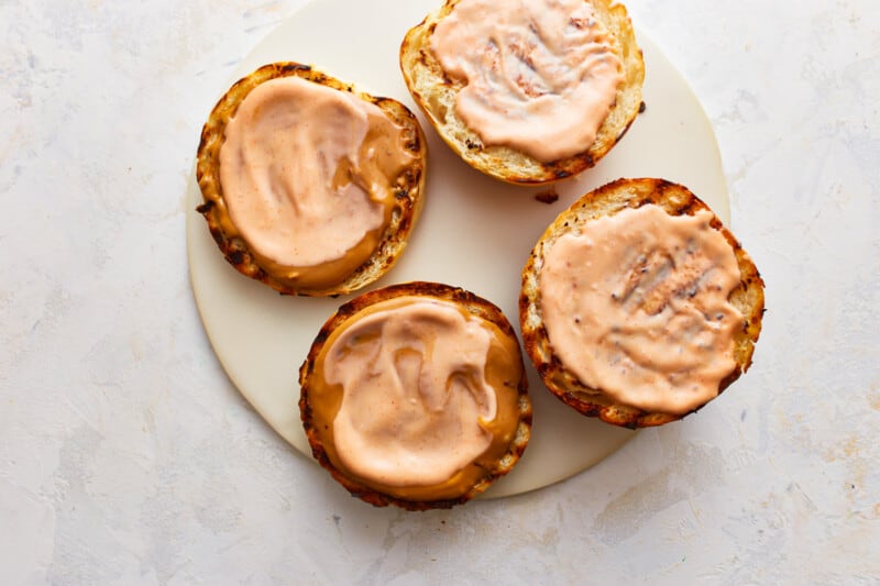 Four sandwiches on a plate with icing on them.