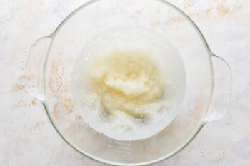 A glass bowl filled with a mixture of flour and sugar.