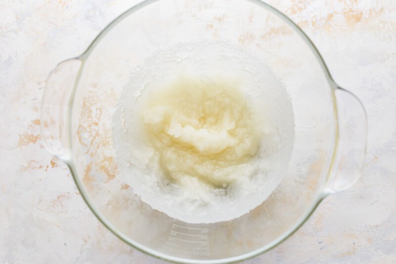 A glass bowl filled with a mixture of flour and sugar.