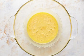 A glass bowl with a yellow liquid in it.