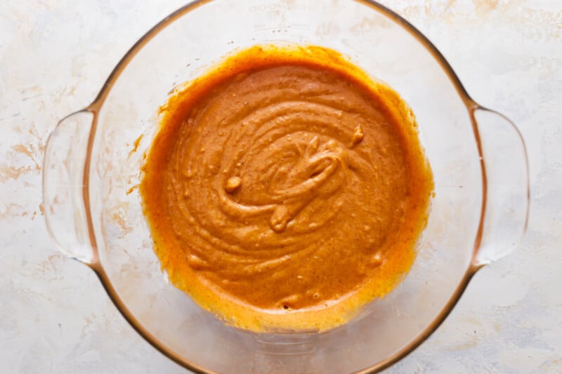 A glass bowl filled with pumpkin batter.