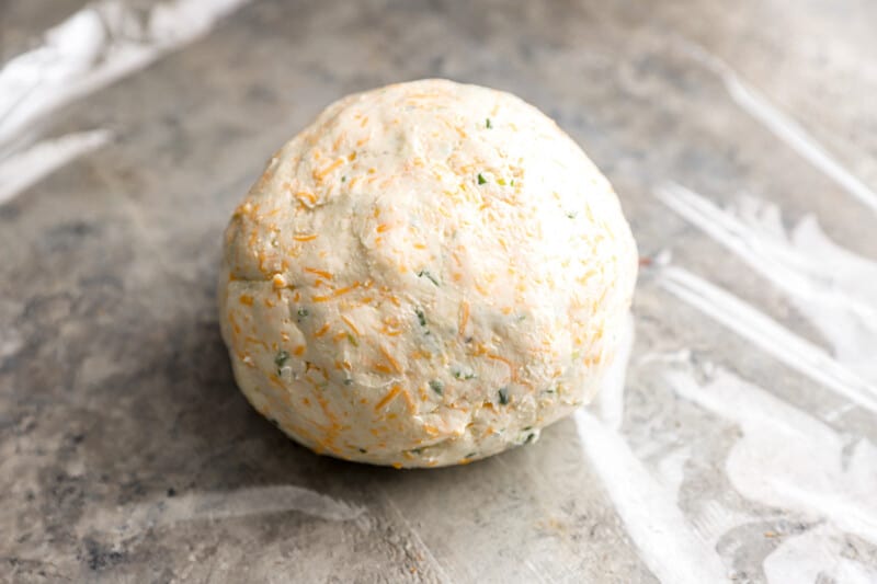 A ball of dough sitting on top of a piece of plastic.