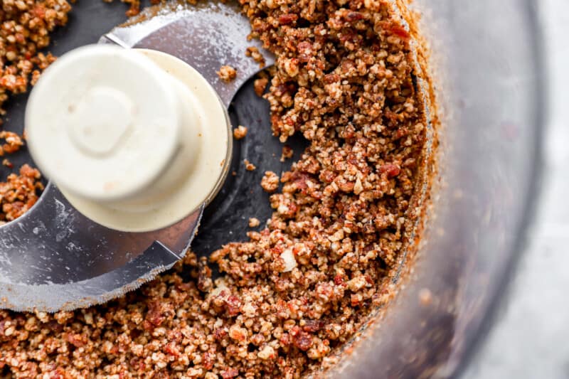 A food processor filled with granola and nuts.