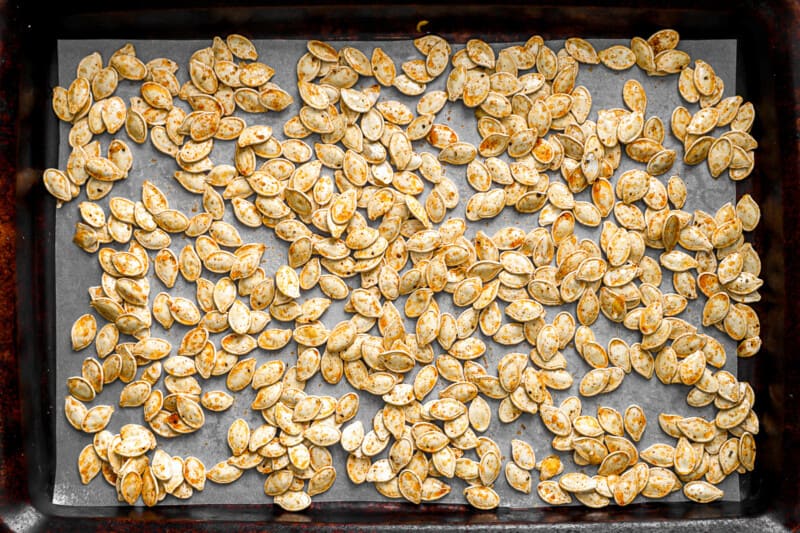 Roasted pumpkin seeds on a tray.