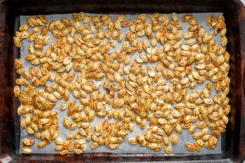 Roasted pumpkin seeds on a baking sheet.