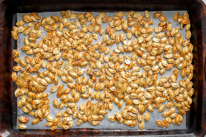 Roasted pumpkin seeds on a baking sheet.
