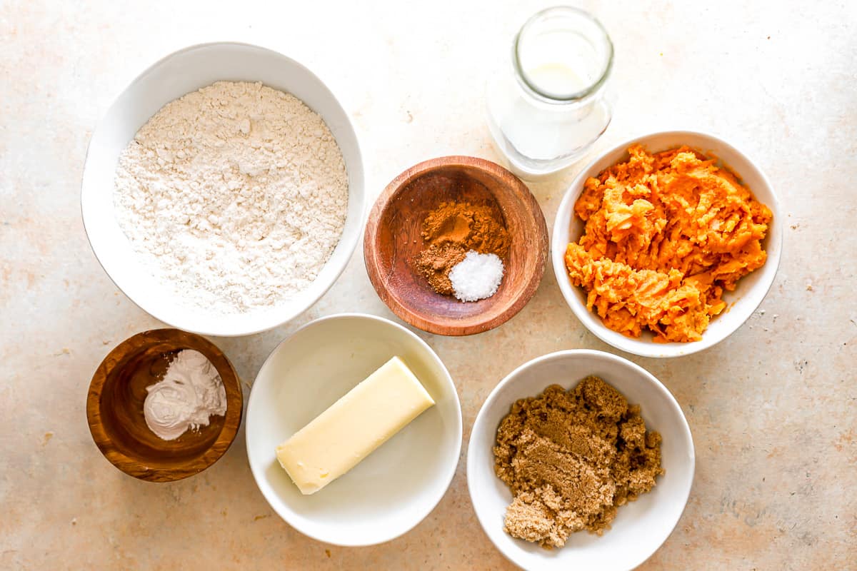 A bowl of flour, butter, sugar, eggs and other ingredients on a table.