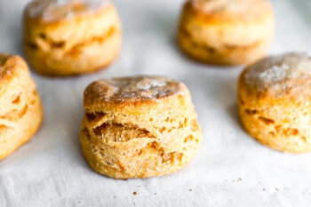 Scones with powdered sugar on a baking sheet.