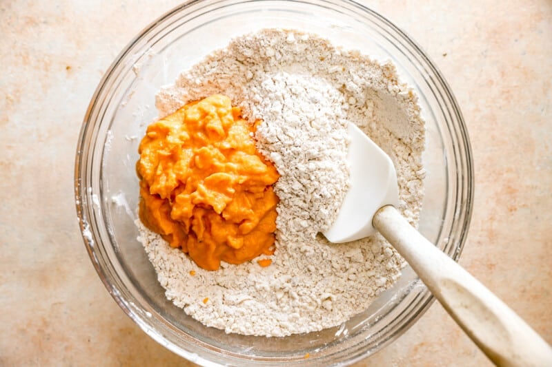 A bowl filled with flour and a spoon.