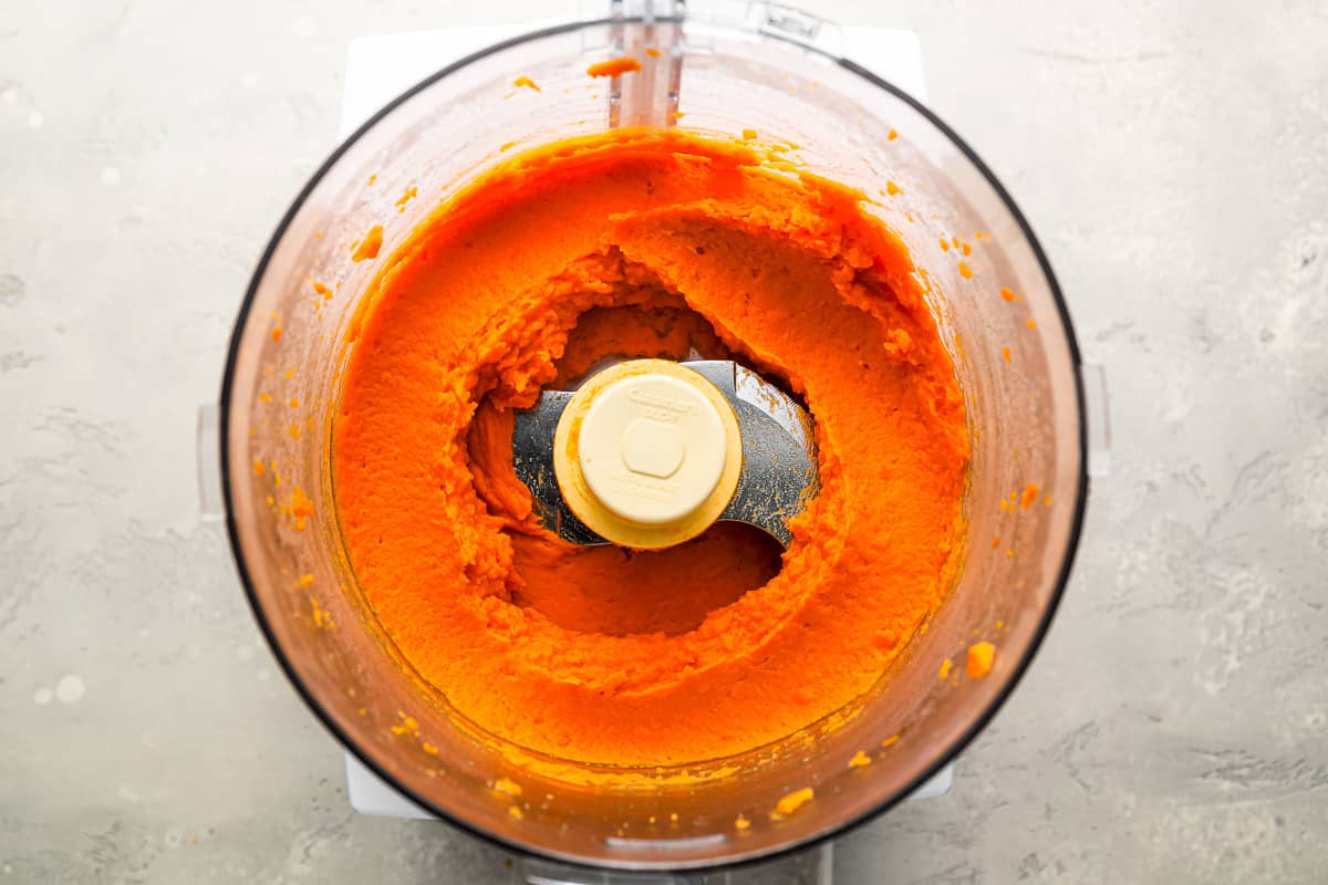 A food processor filled with carrots.