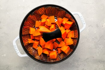 A colander with carrots in it.