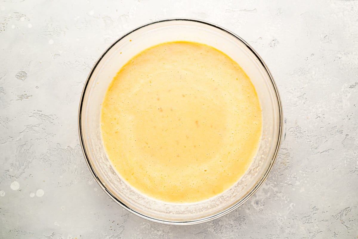 A glass bowl with a yellow liquid in it.