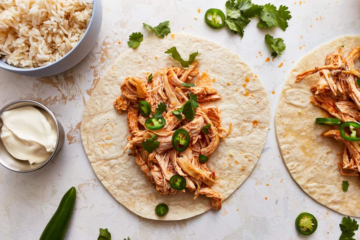 Shredded chicken tacos with rice and jalapenos.