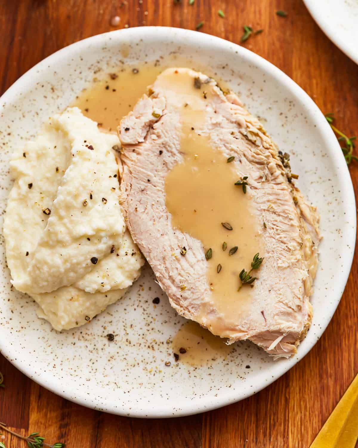 Instant pot turkey breast with gravy and mashed potatoes on a plate.
