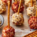 mini cheese balls with bacon and pretzels on sticks.