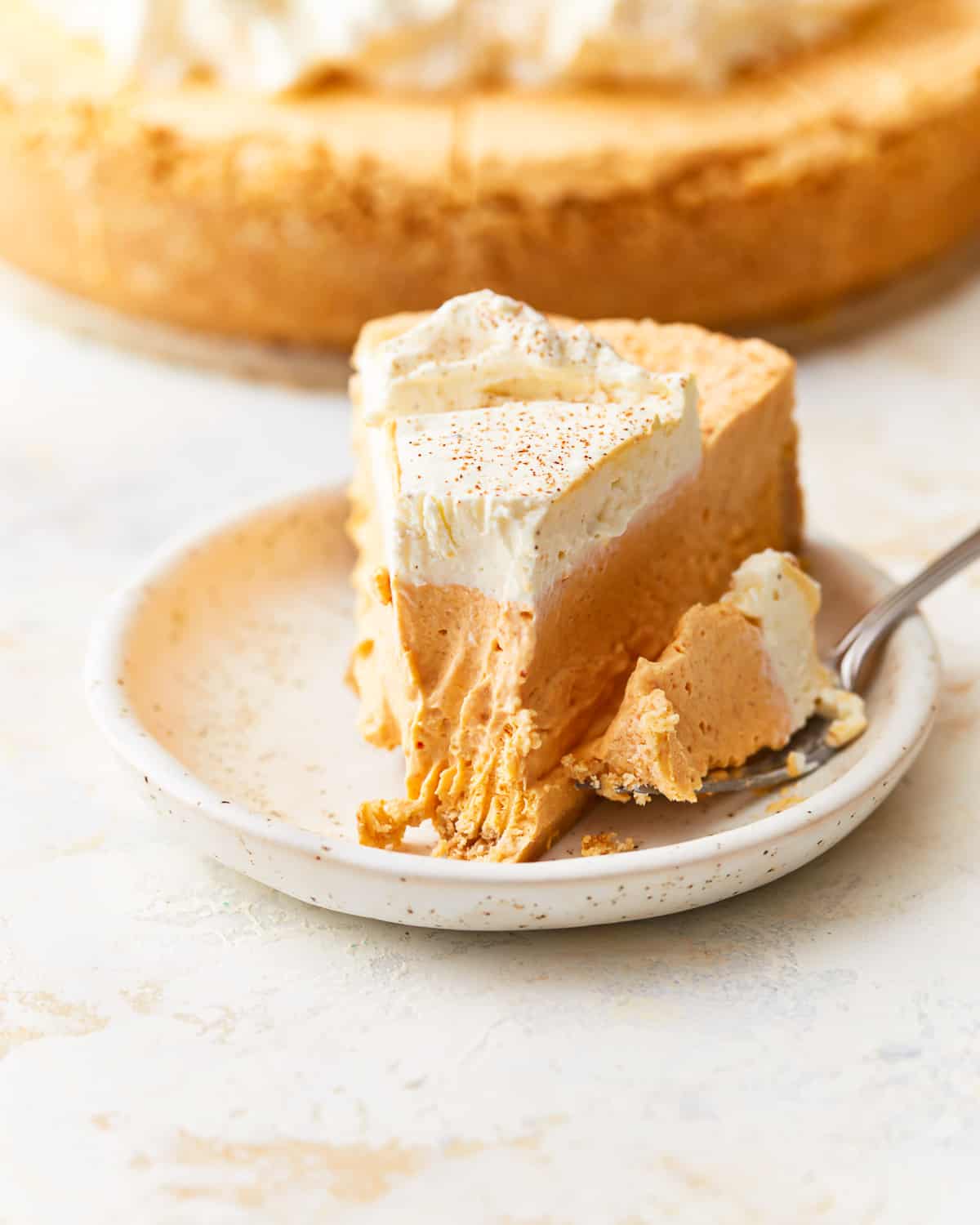 A slice of no bake pumpkin cheesecake on a plate.