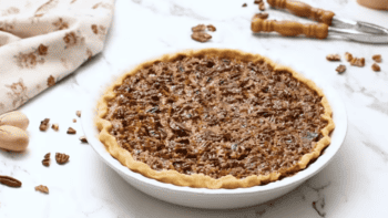 Classic Pecan pie in a white bowl on a marble table.