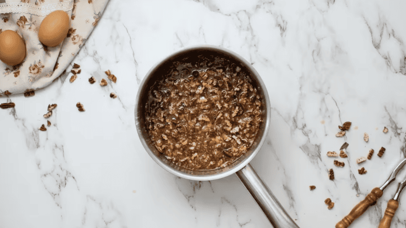 A classic Pecan Pie with nuts on a marble countertop.