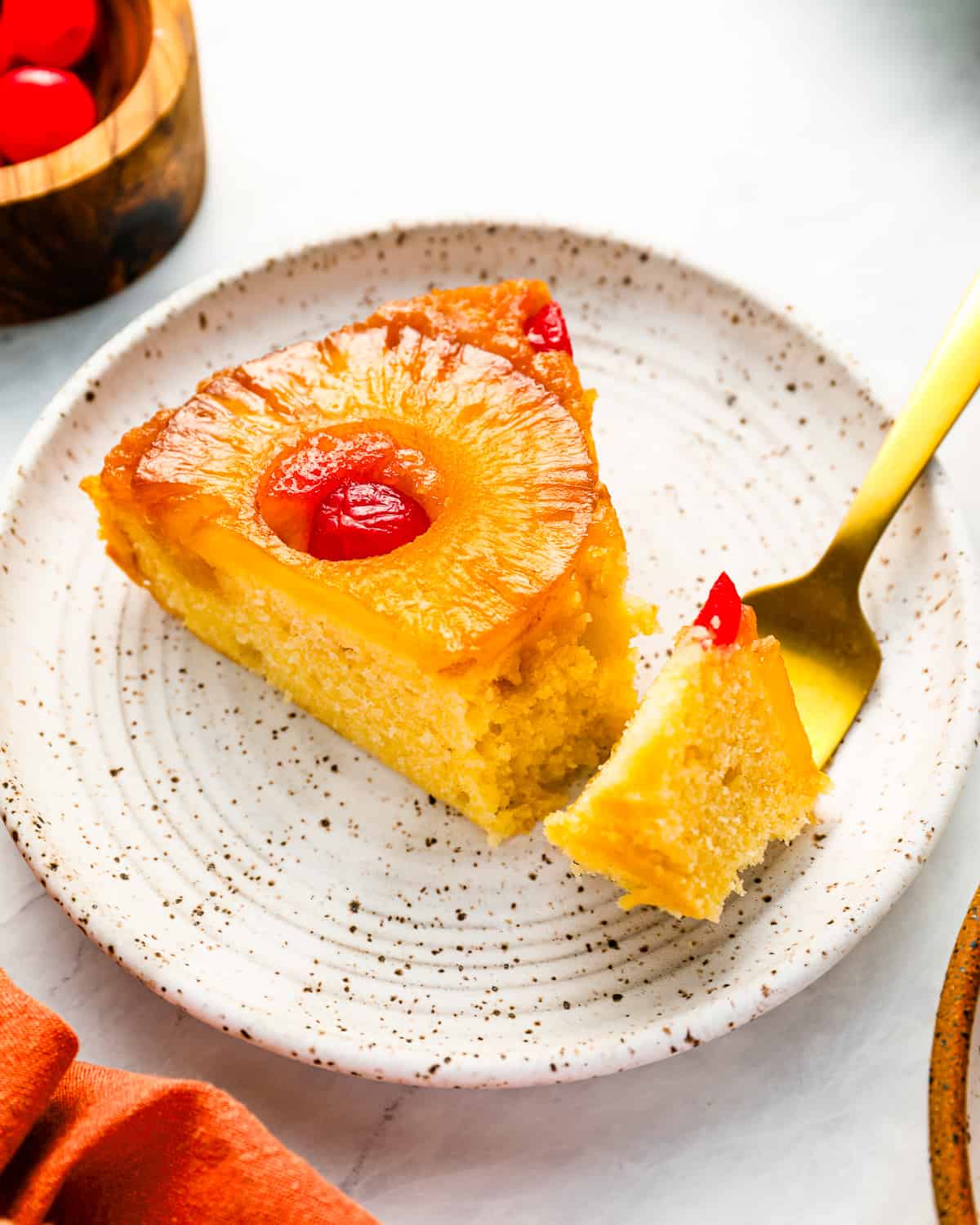 A slice of pineapple upside down cake on a plate.