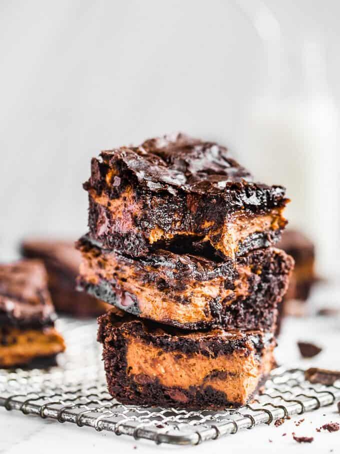 Stacked chocolate brownies with a layer of pumpkin filling in the middle