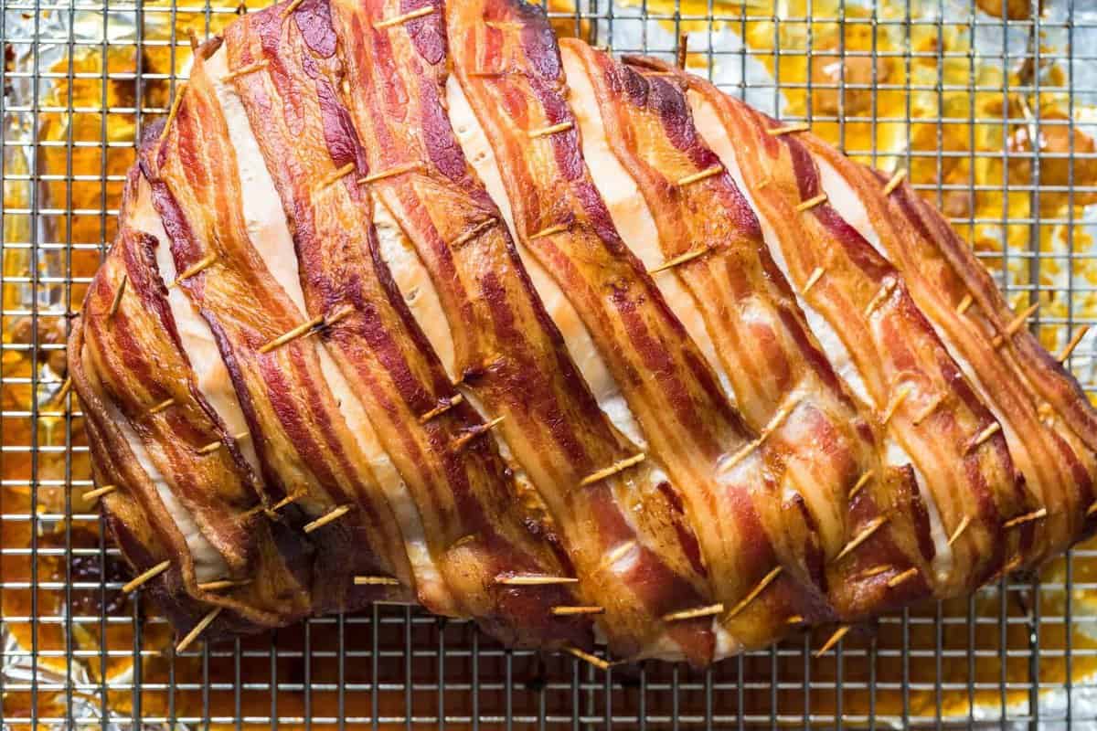 The bacon wrapped turkey breast on a cooling rack