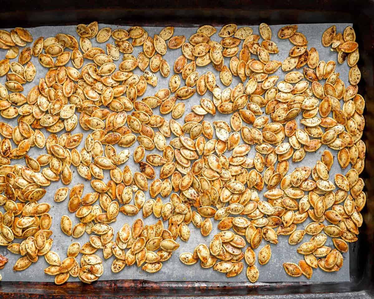 Roasted pumpkin seeds on a baking sheet.