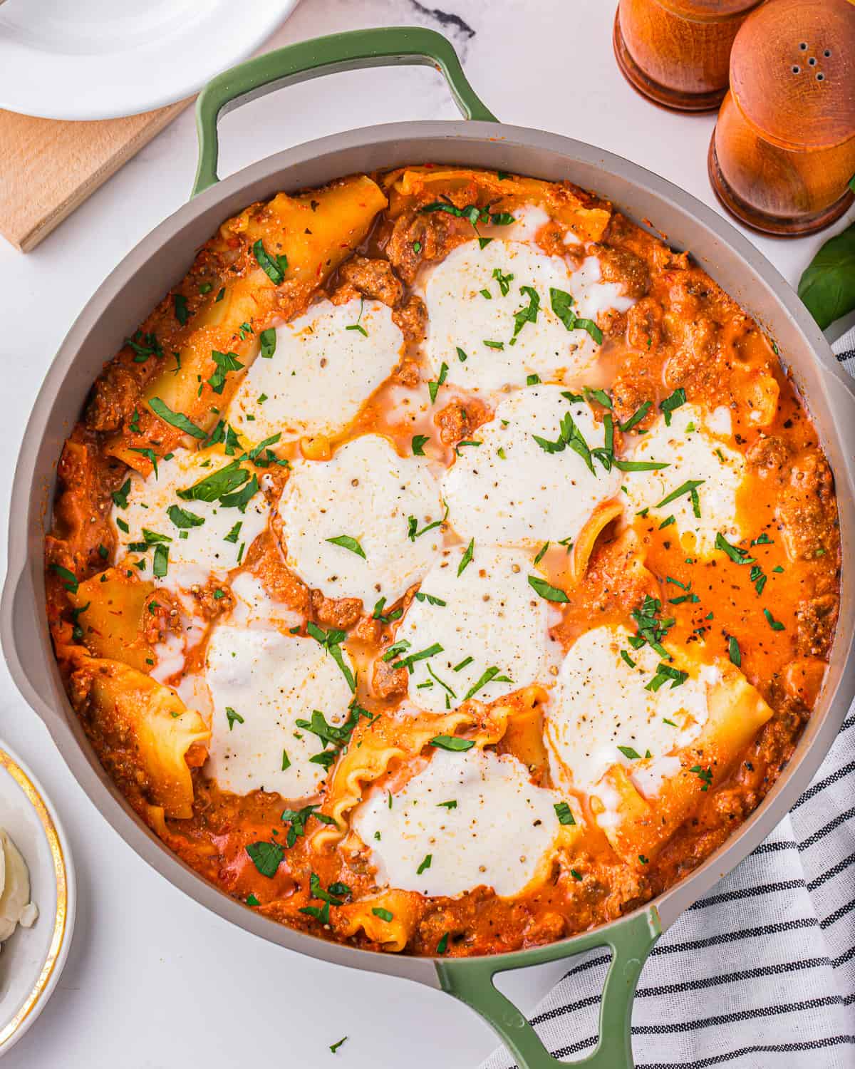 Lasagna in a skillet with mozzarella cheese on top.