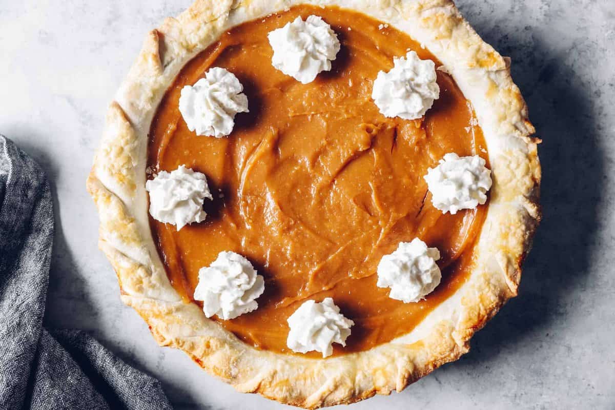 overhead view of a whole caramel pie with whipped topping