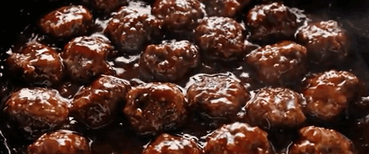Simmering the meatballs in the sauce. 