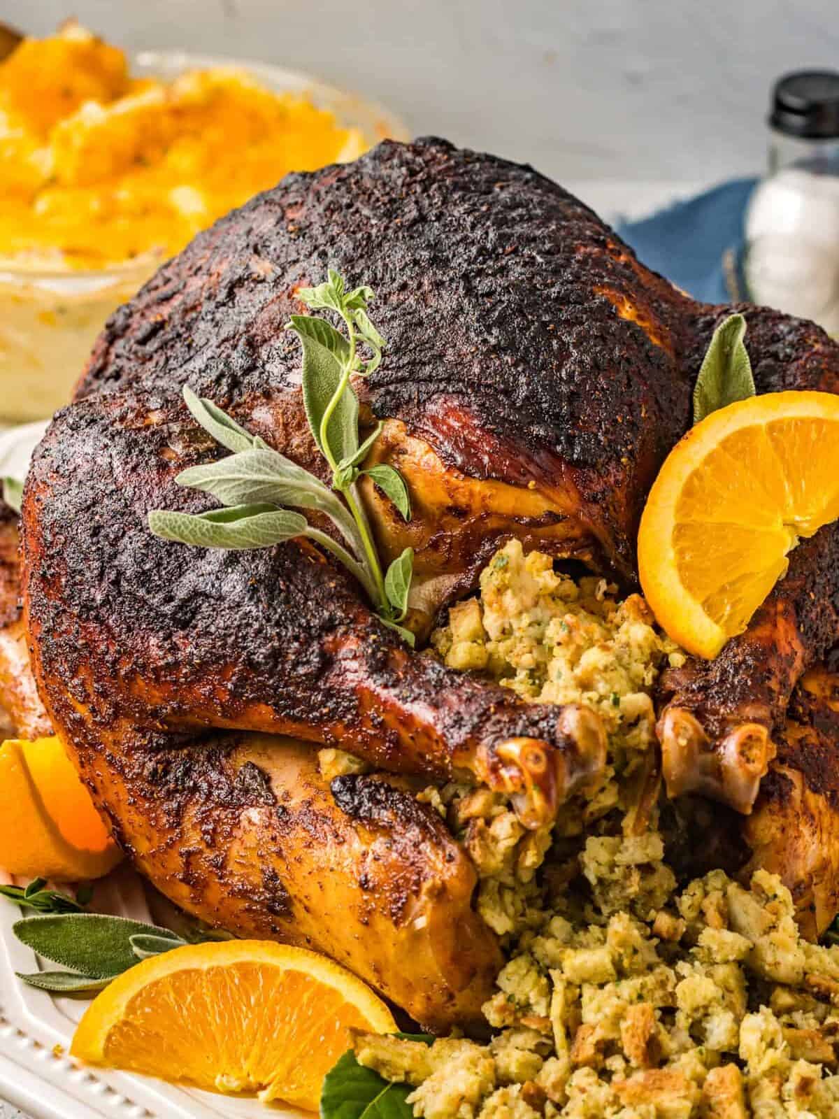 dry brined turkey with stuffing orange slices and herbs.