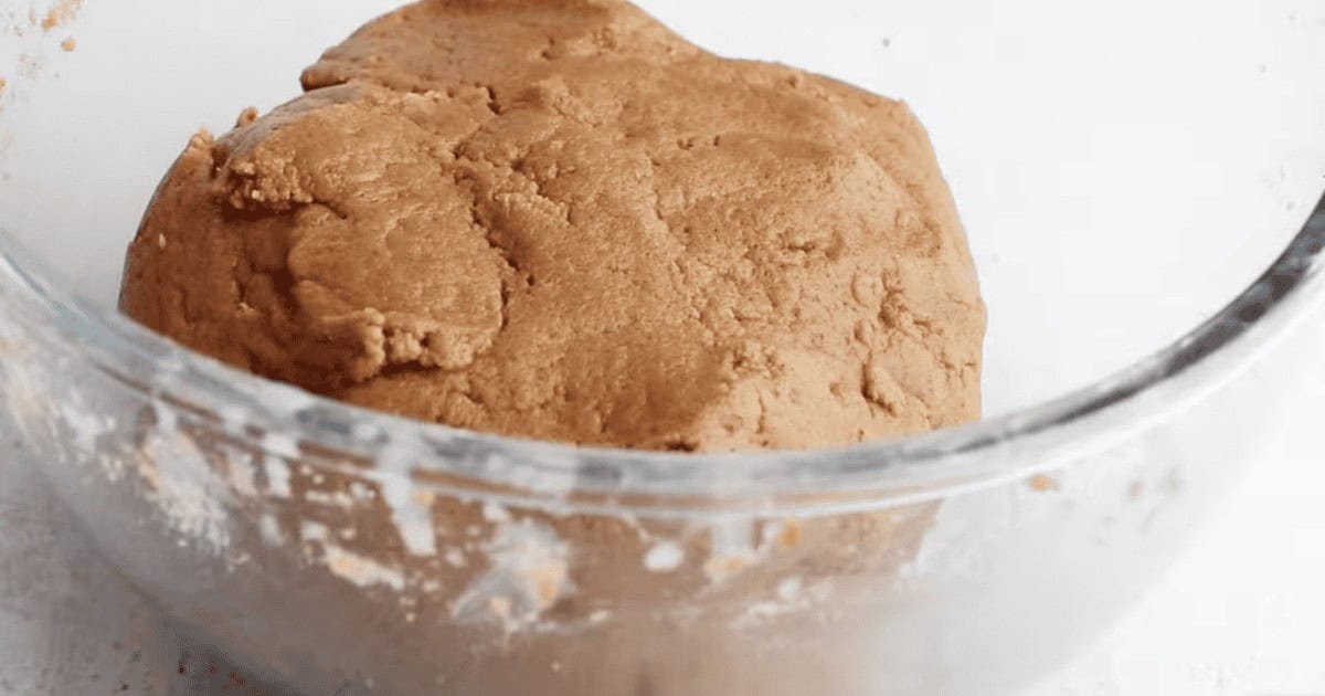 Molasses cookie dough resting in a glass bowl.