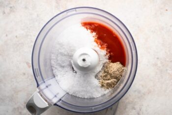 a food processor filled with ingredients for a smoky bbq sauce.