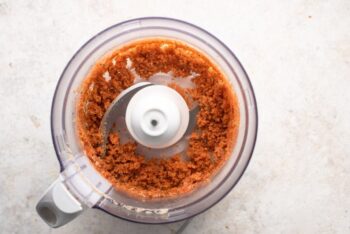A food processor filled with a mixture of popcorn and salt.