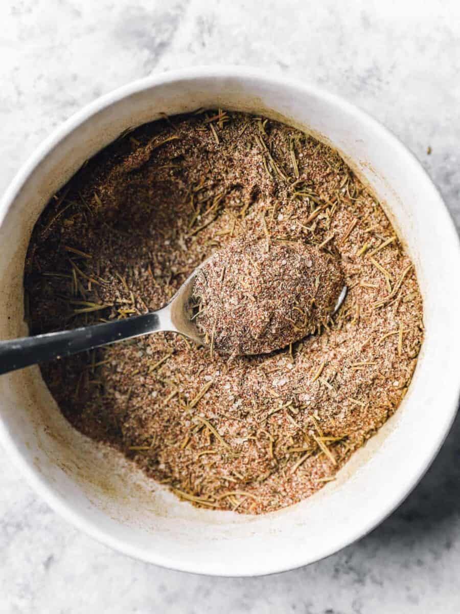 spices in a white bowl with a spoon.