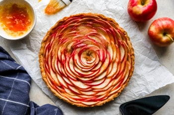 A tart with apples and a sauce on top.