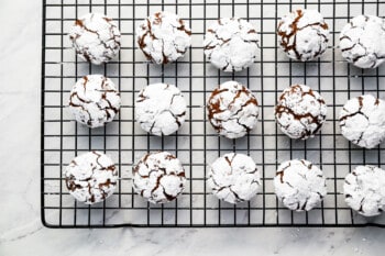 Chocolate crinkle cookies on a cooling rack.