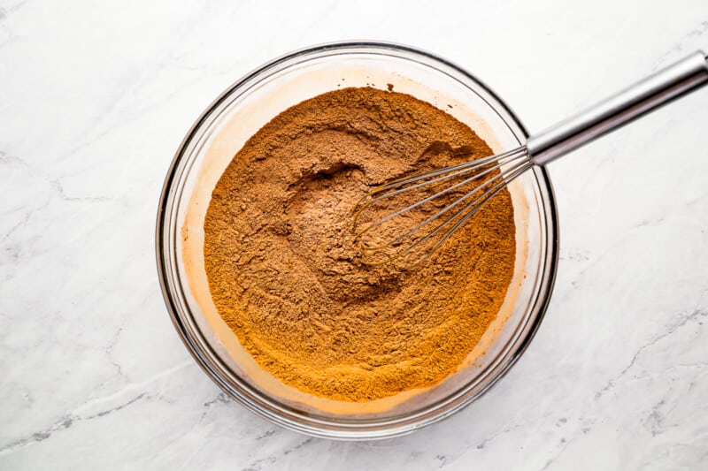 A bowl with a whisk full of cinnamon powder.