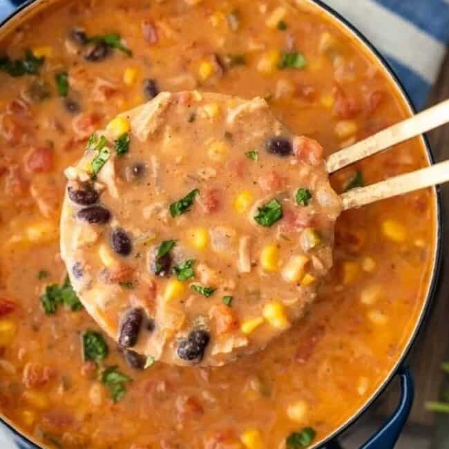 Creamy Mexican chicken tortilla soup in a pot with wooden spoons.