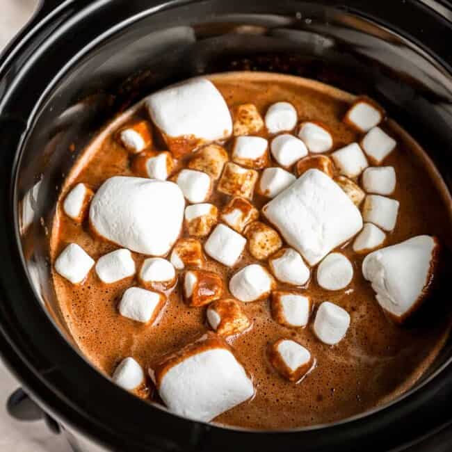 A crock pot filled with chocolate and marshmallows.